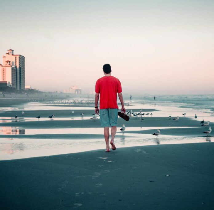 Man walking on the beach without shoes