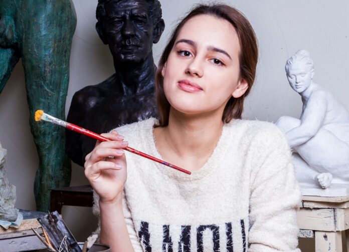 Girl holding a paintbrush in an art studio